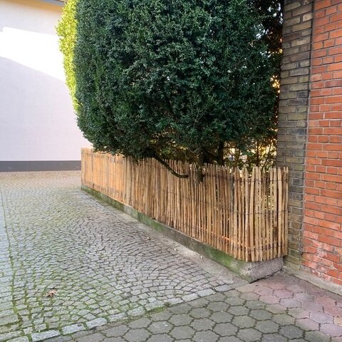 Staketenzaun auf Mauer im Garten 